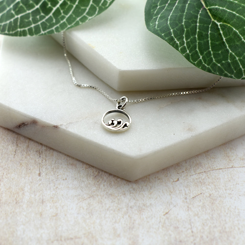 Smile encircled crashing waves pendant